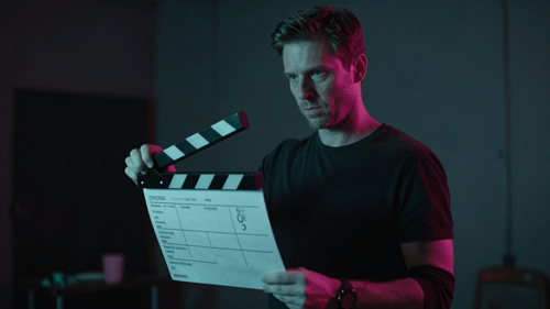Film director holding a storyboard on a dim set